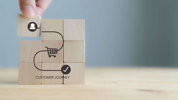 Customer Journey Konzept auf Holzwürfeln auf grauem Hintergrund. Business und Social Media Marketing, Content Marketing, Kauf, Storytelling, SEO, Bewusstsein, werben, Online-Marketing und Promotion. 